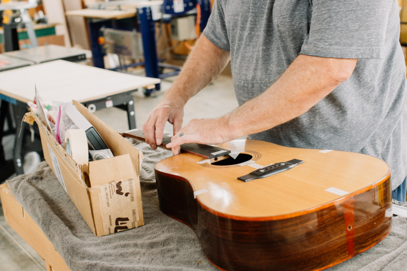 A man working on a guitar project in the Makerspace